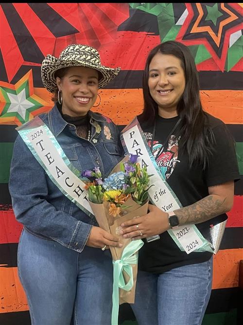 teachers of the year smiling at the camera with flowers