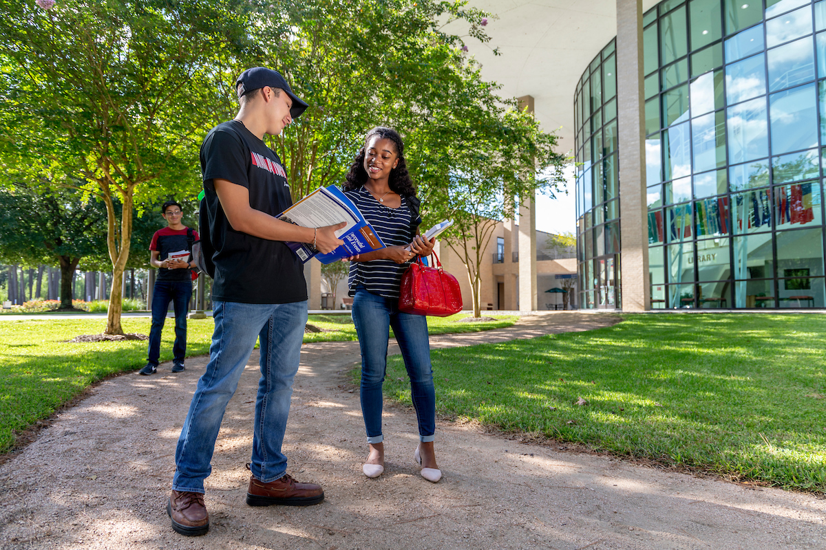 spring early college photo with students standing talking to each other on a path