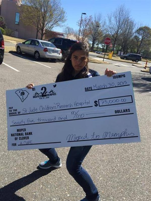 girl smiling with the donation check