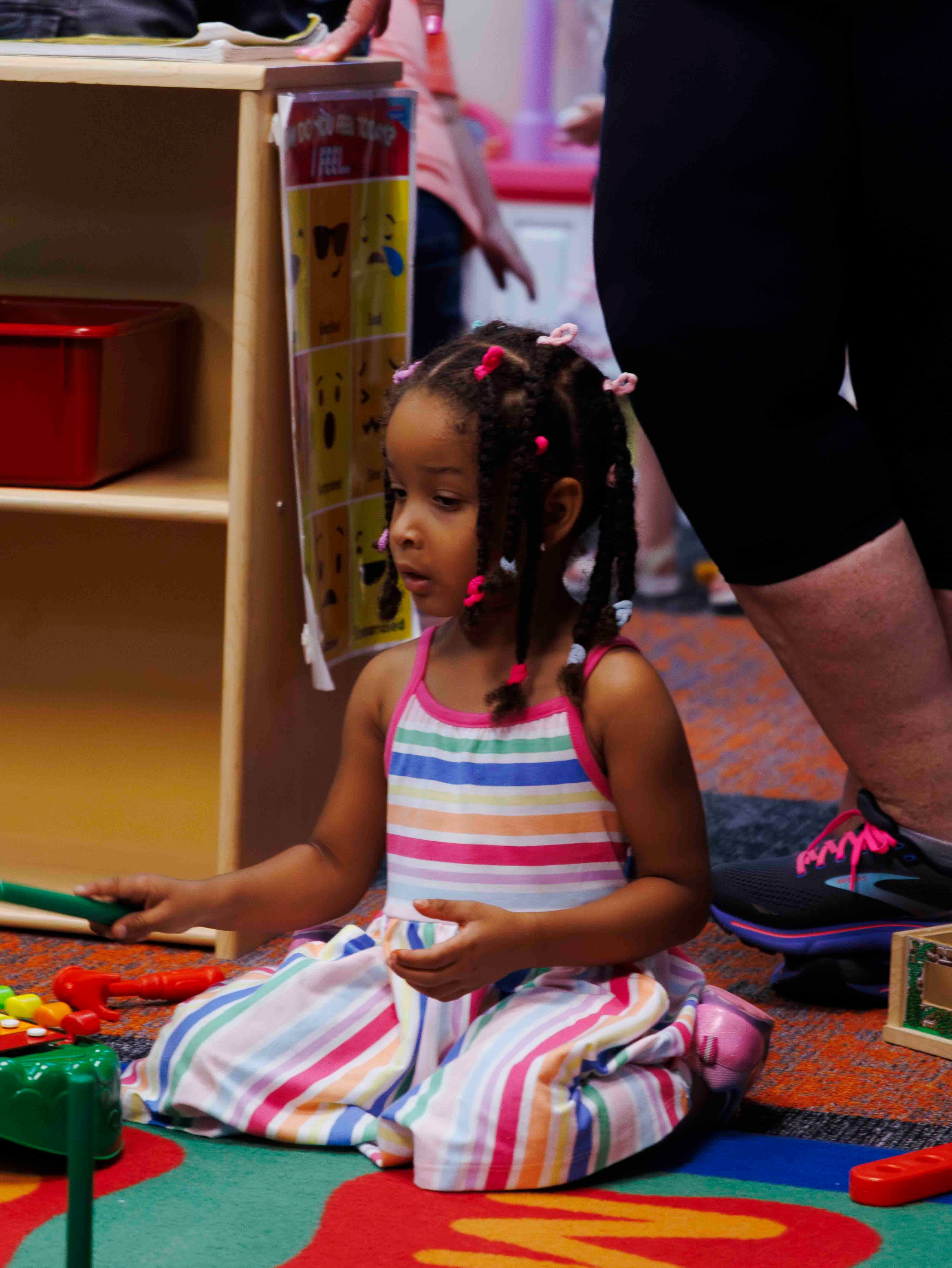 A Kramer Preschool student sits on the classroom carpet during the school's open house event in August 2024.