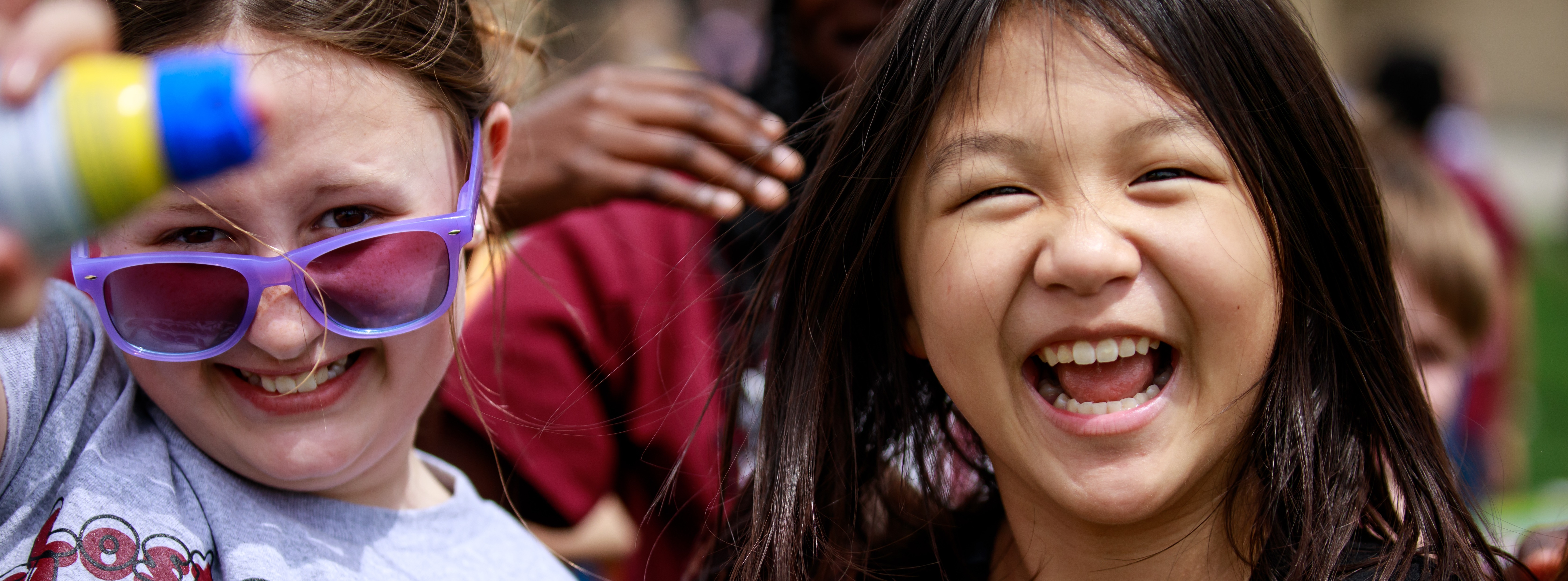 Two young girls smile big for a photo during the Lost Creek's Field Days in 2024.