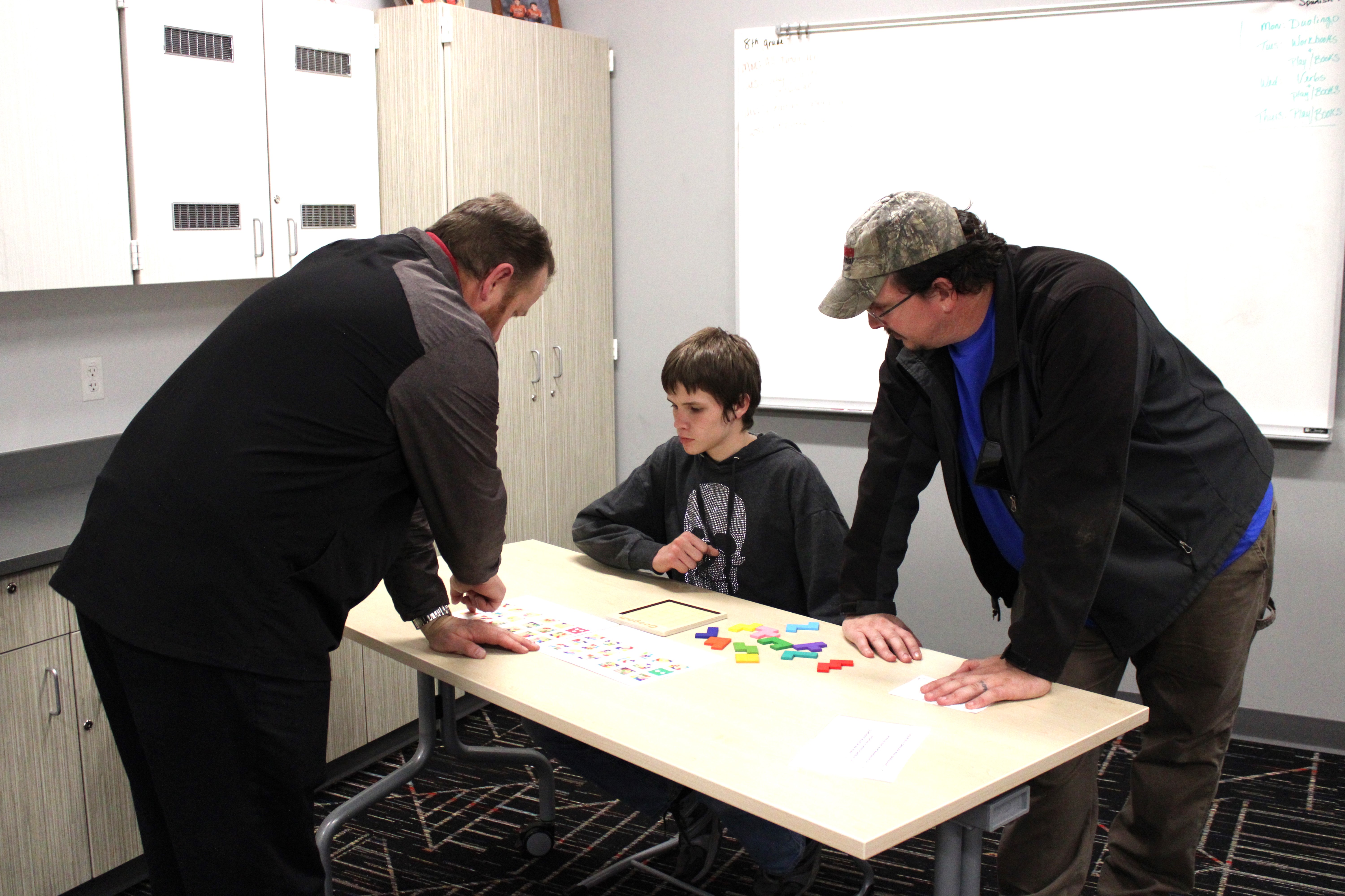 Three people standing at a desk