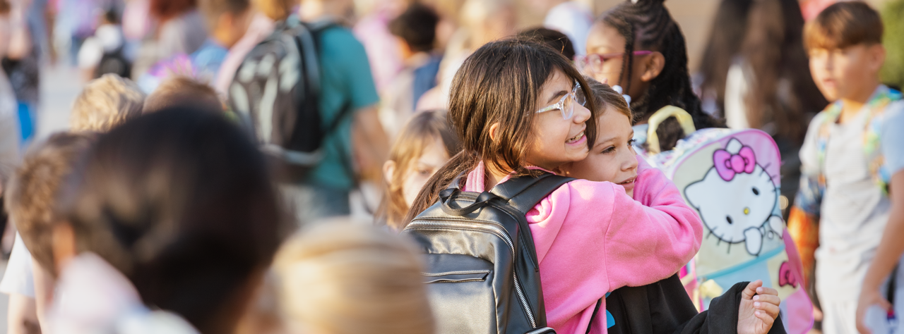 Two students hug on the first day of school outside Centennial Elementary.