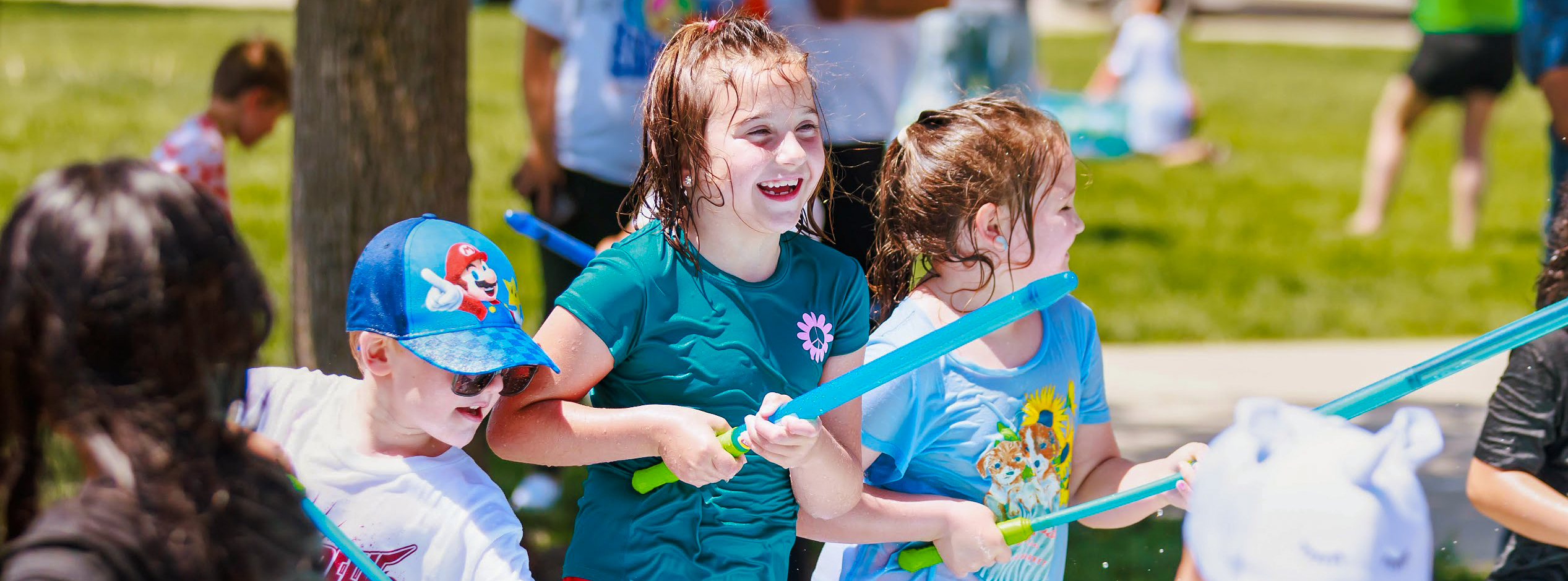 A small group of Lost Creek students hold water and refill water guns during the school's field day in 2025.