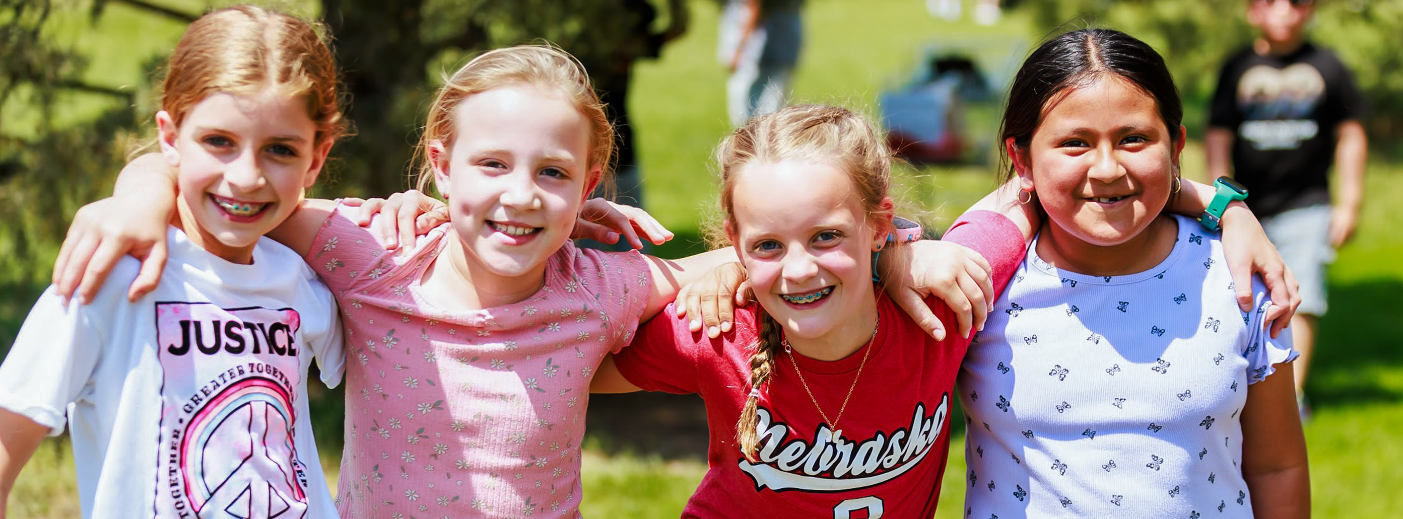 A group of North Park girls pose for a photo during the school's field day. They have arms slung over eachother's shoulders.