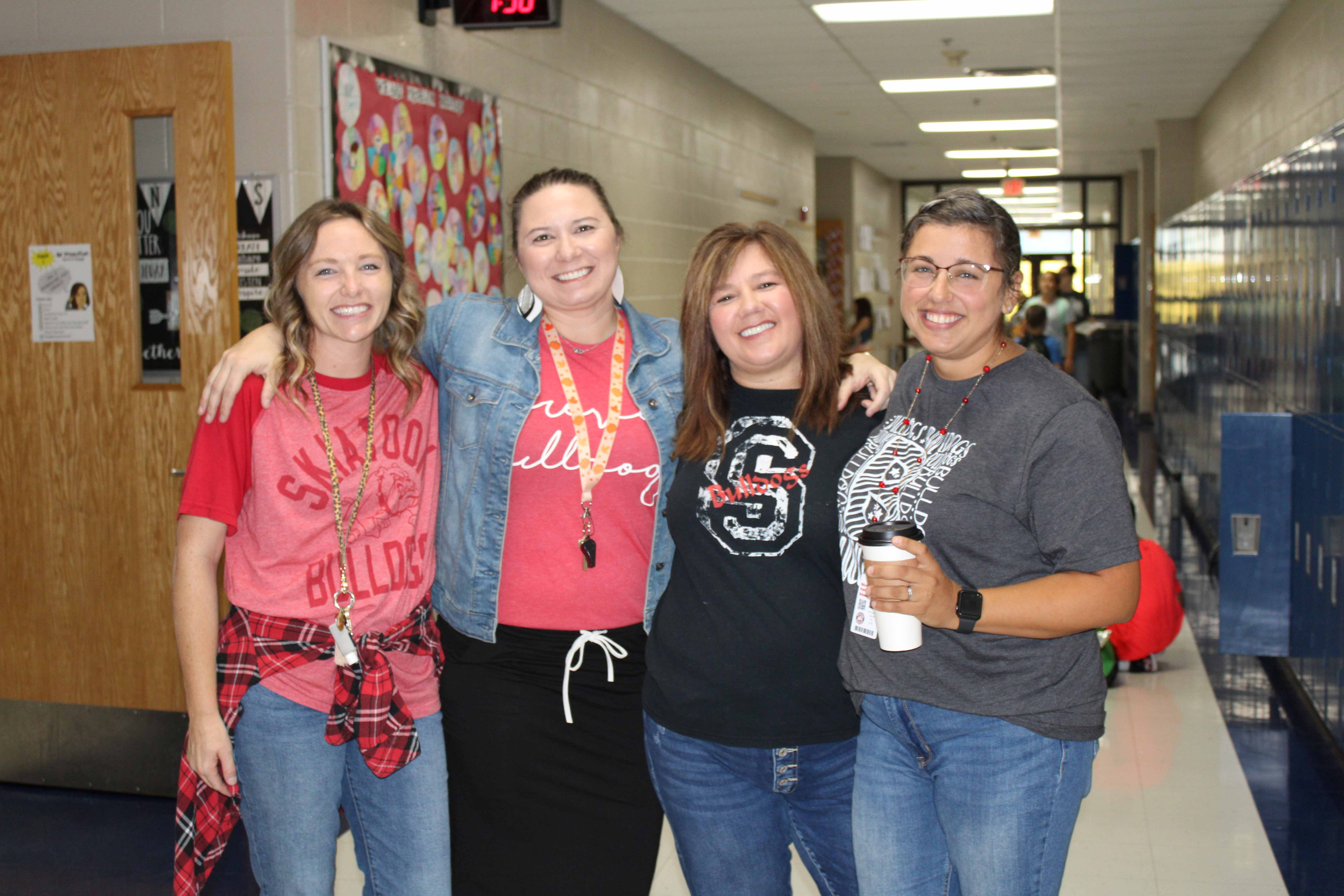 four women standing together, smiling