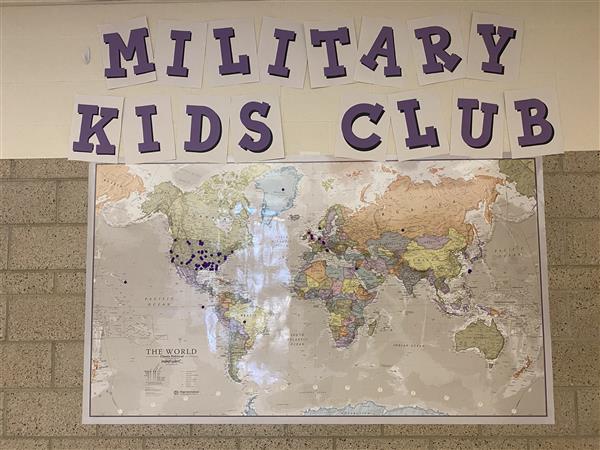 wall that says military kids club and a world map