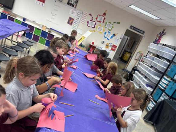 students cutting paper in a classroom