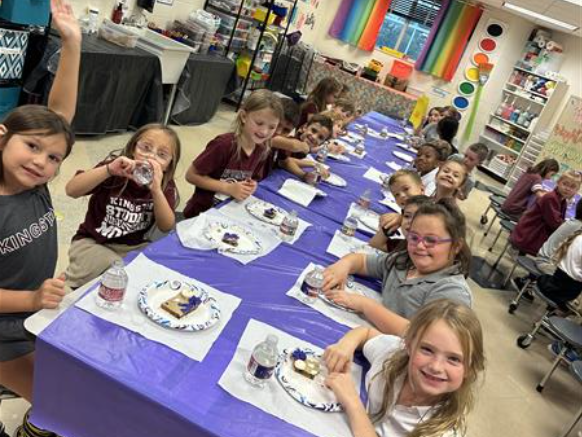 students happy crafting something, part of the class, inside a classroom