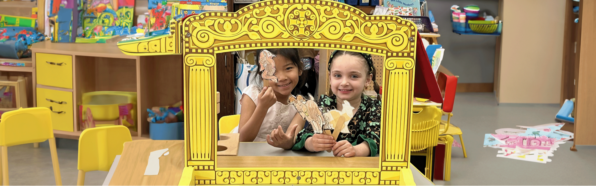 These are two pre-school students using puppet theater to retell a story