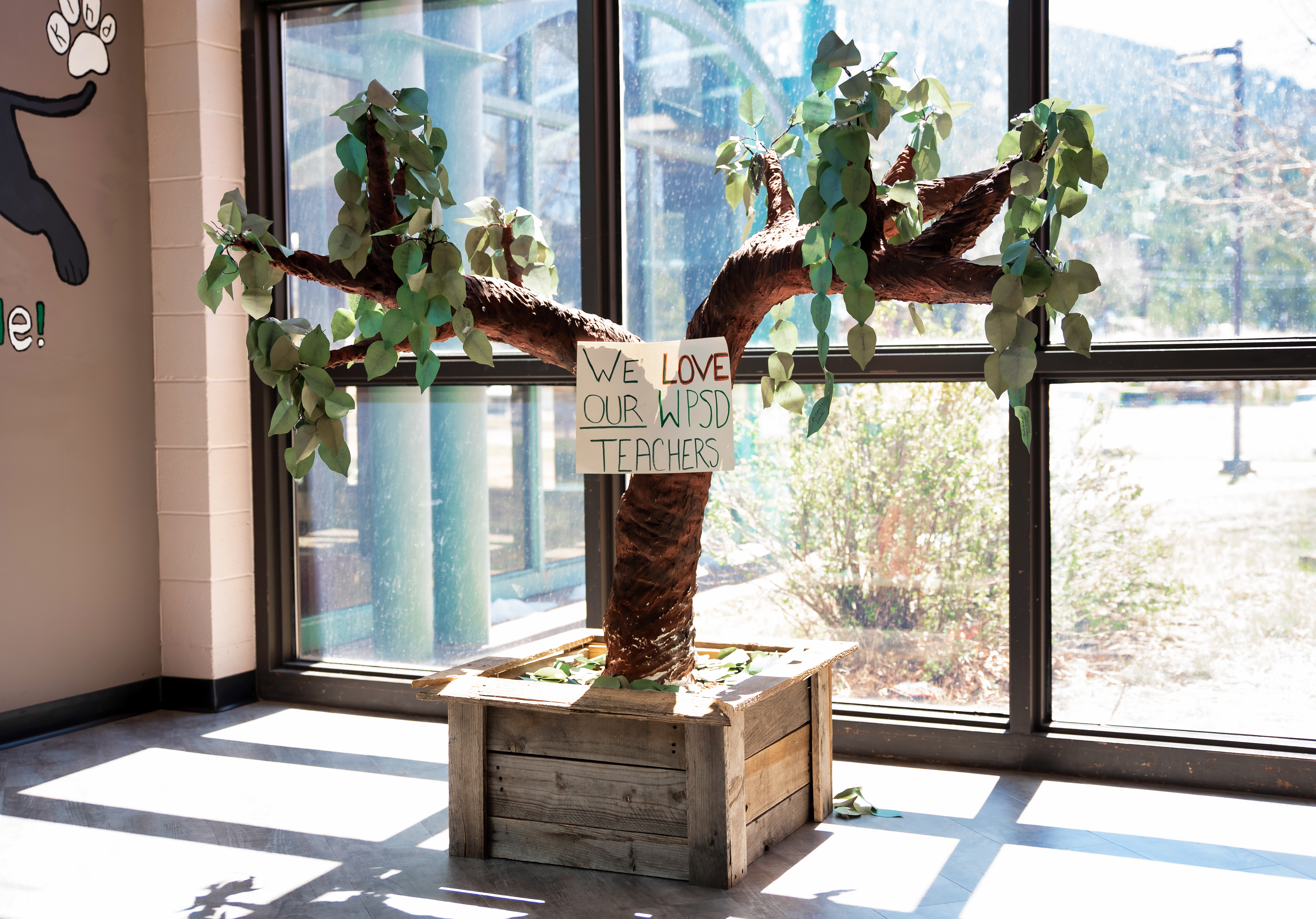 Image of a tree inside a building with a sign that says, We Love Our WPSD Teachers.