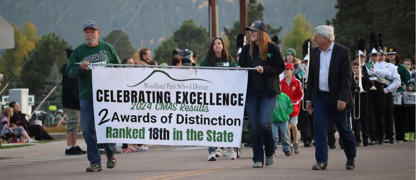 BOE members walking in the homecoming parade holding a banner