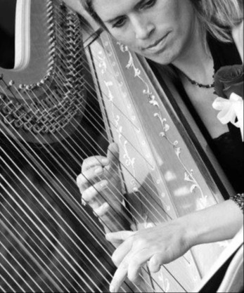 Kimberly Founds in a black and white photo playing the harp.