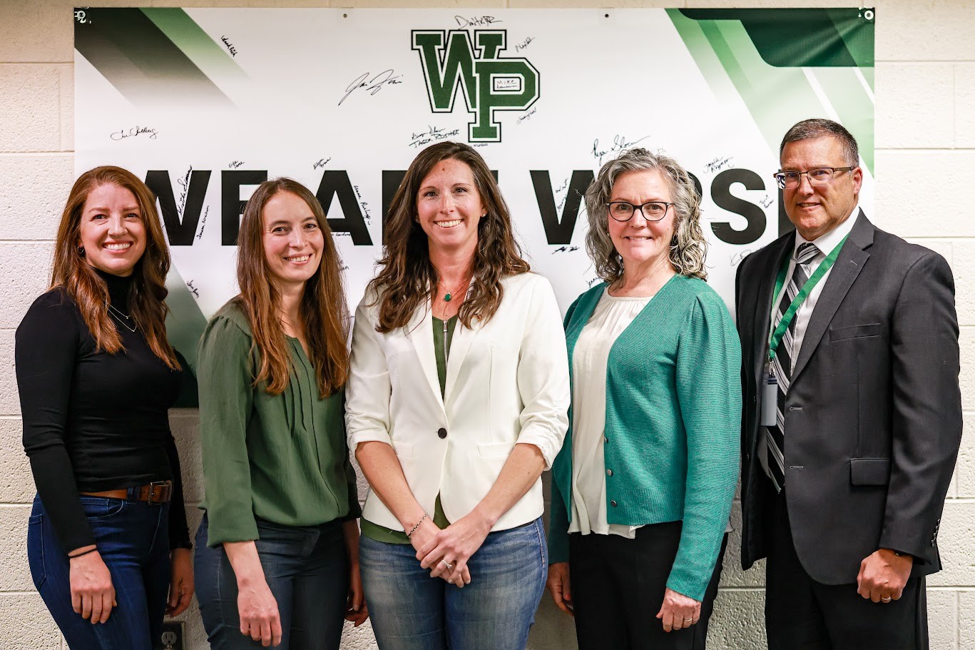The five board members pose for a picture in the board room