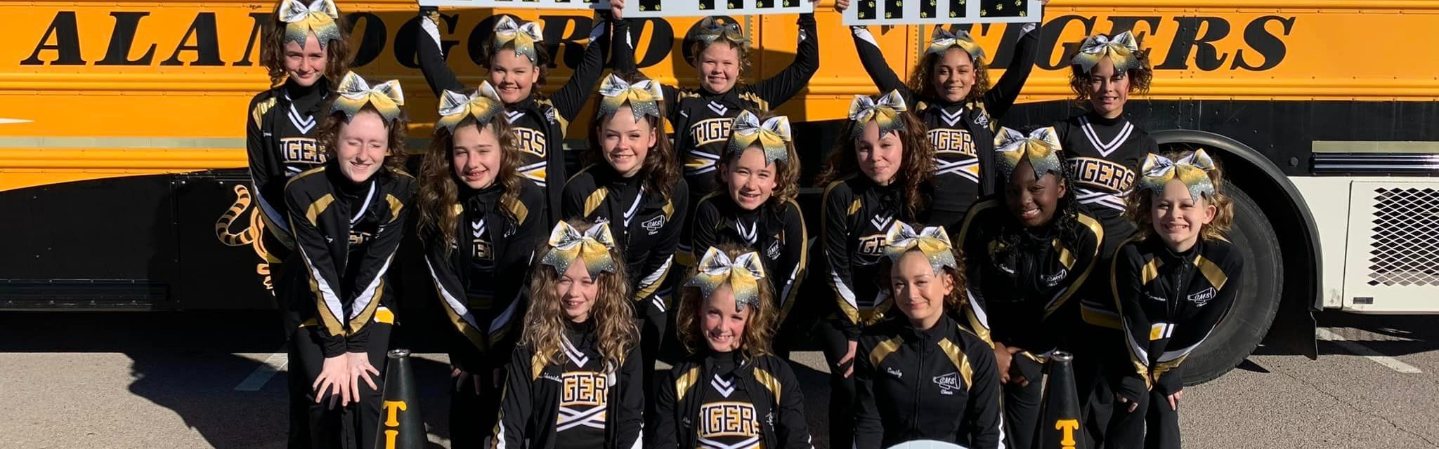 Cheerleaders in front of a bus