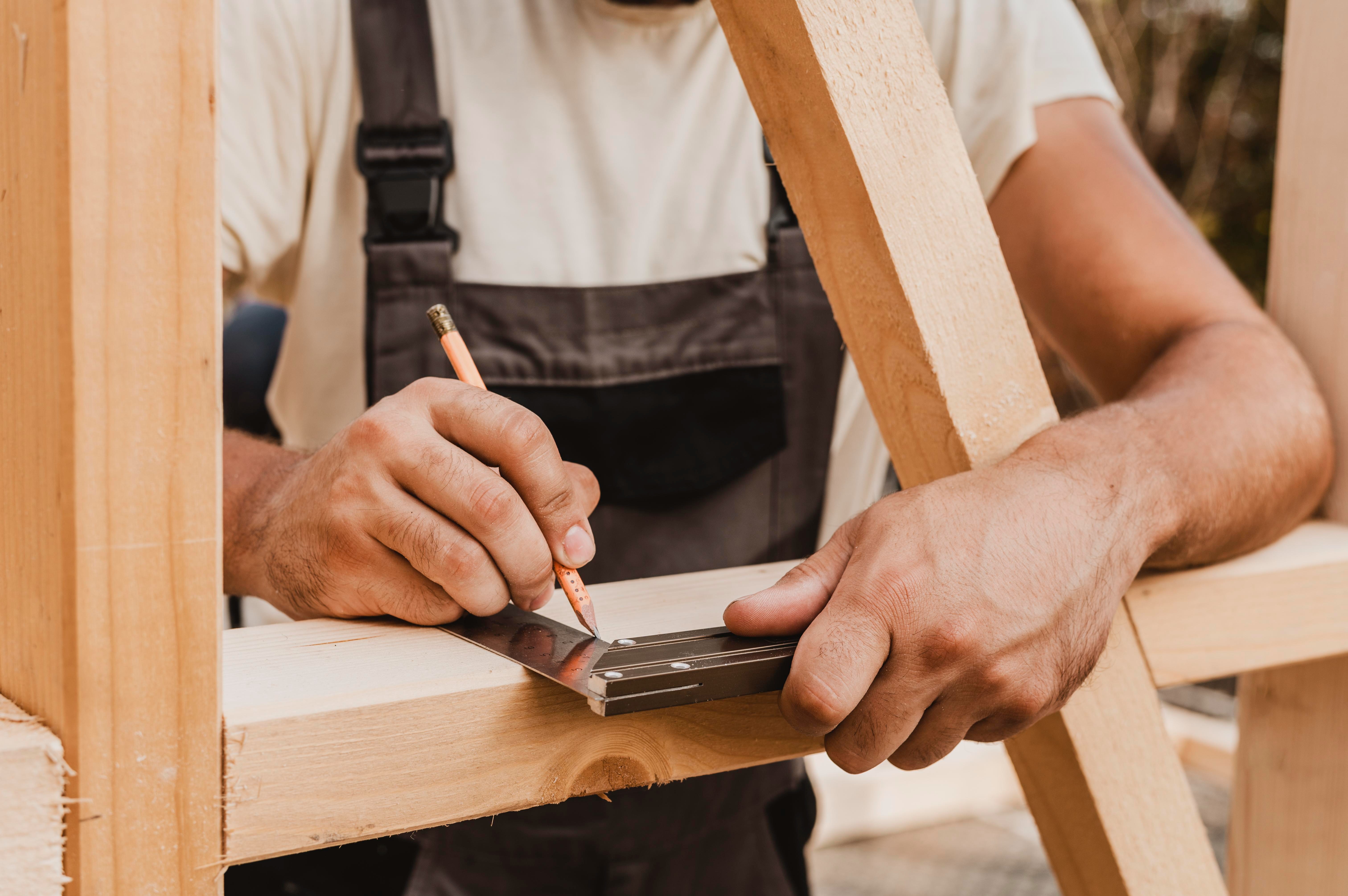 carpenter making measurements on planks of wood
