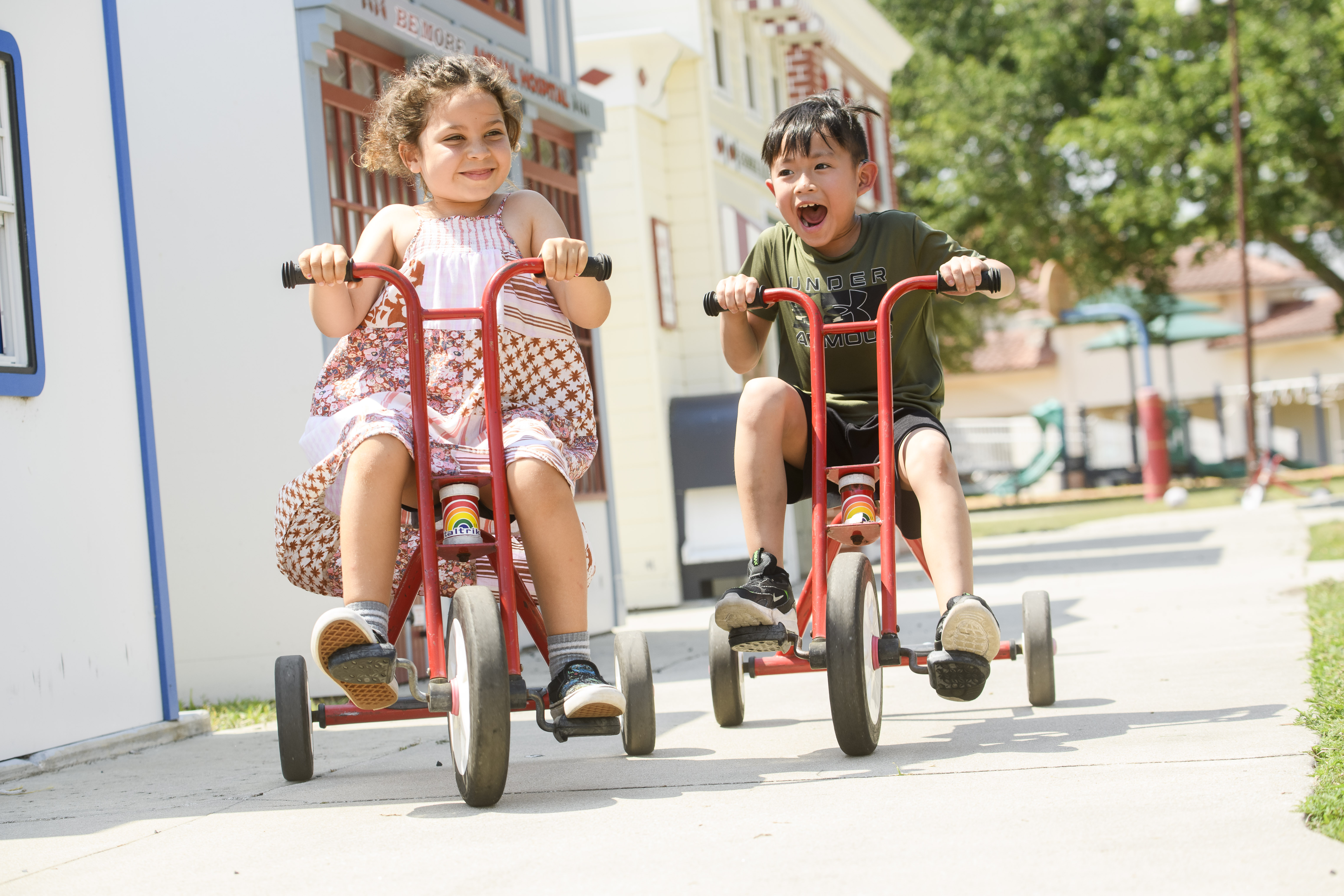 Two students riding trikes in Kids Town