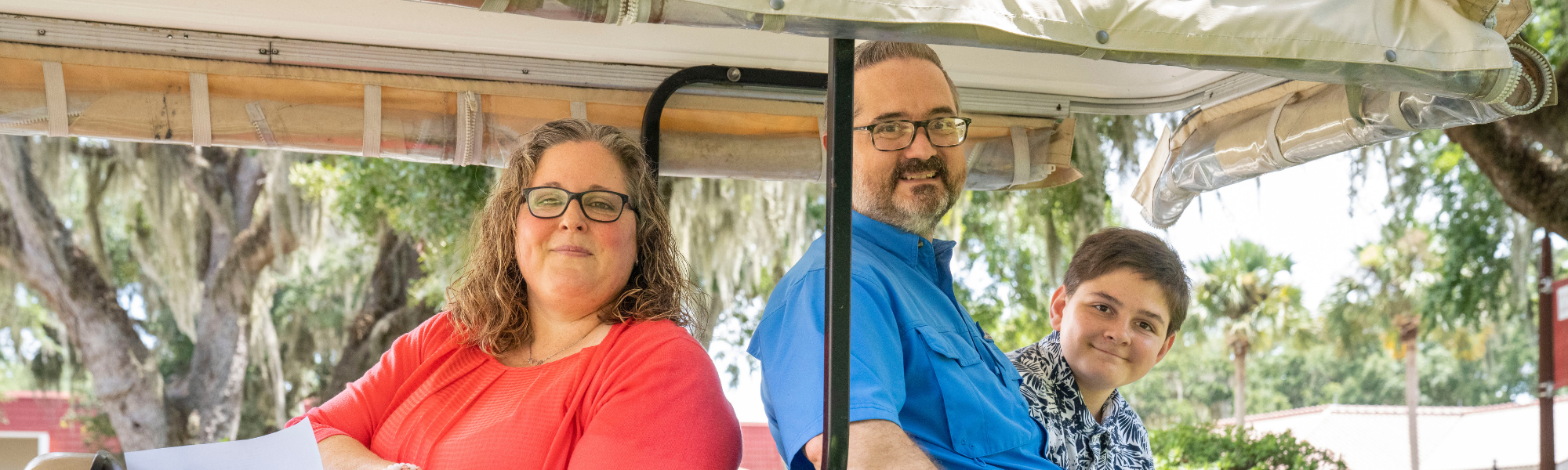 Parents and child in golf cart