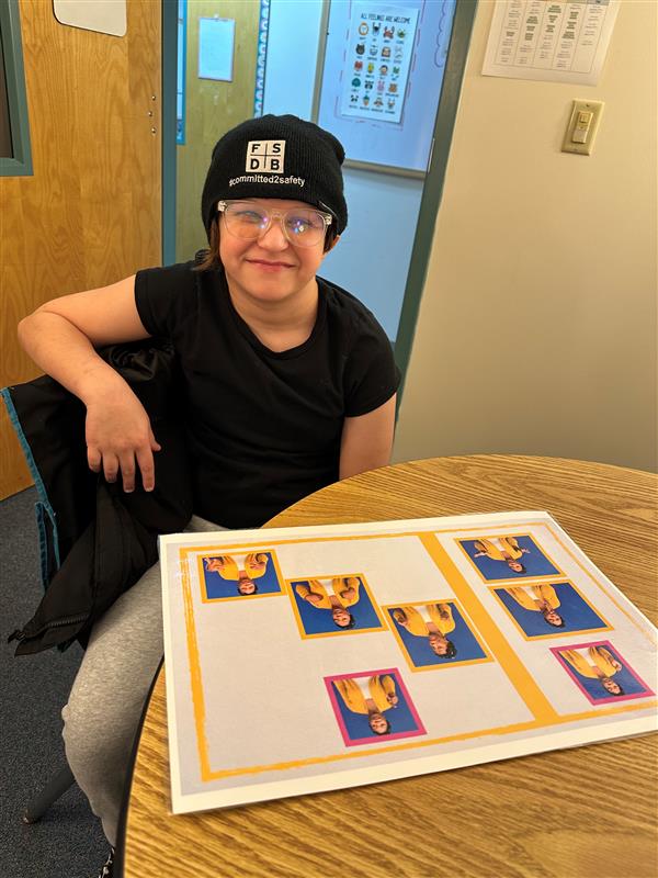 Deaf student looking a  poster board with pictures