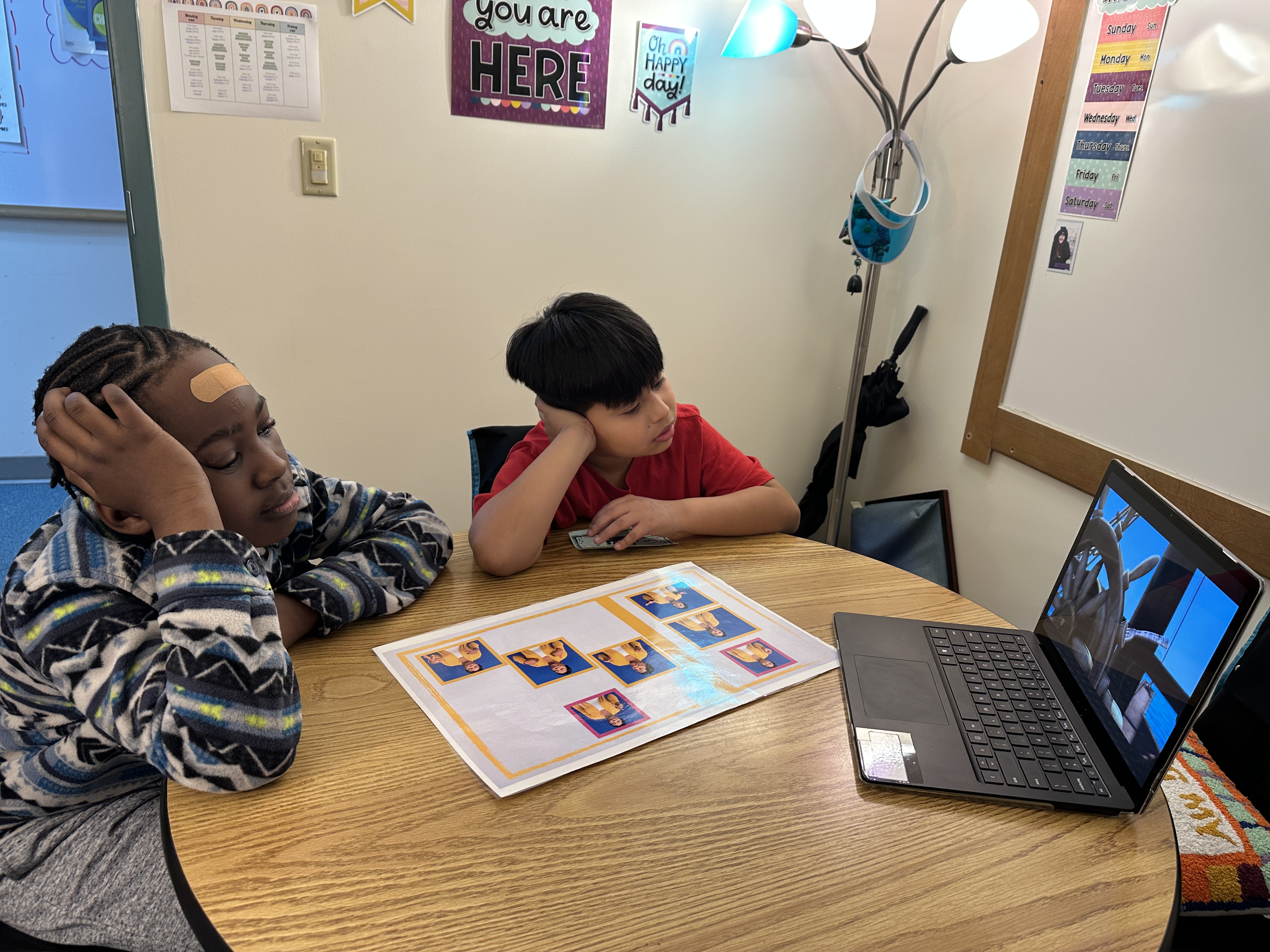 Two boys watching a video on a laptop.