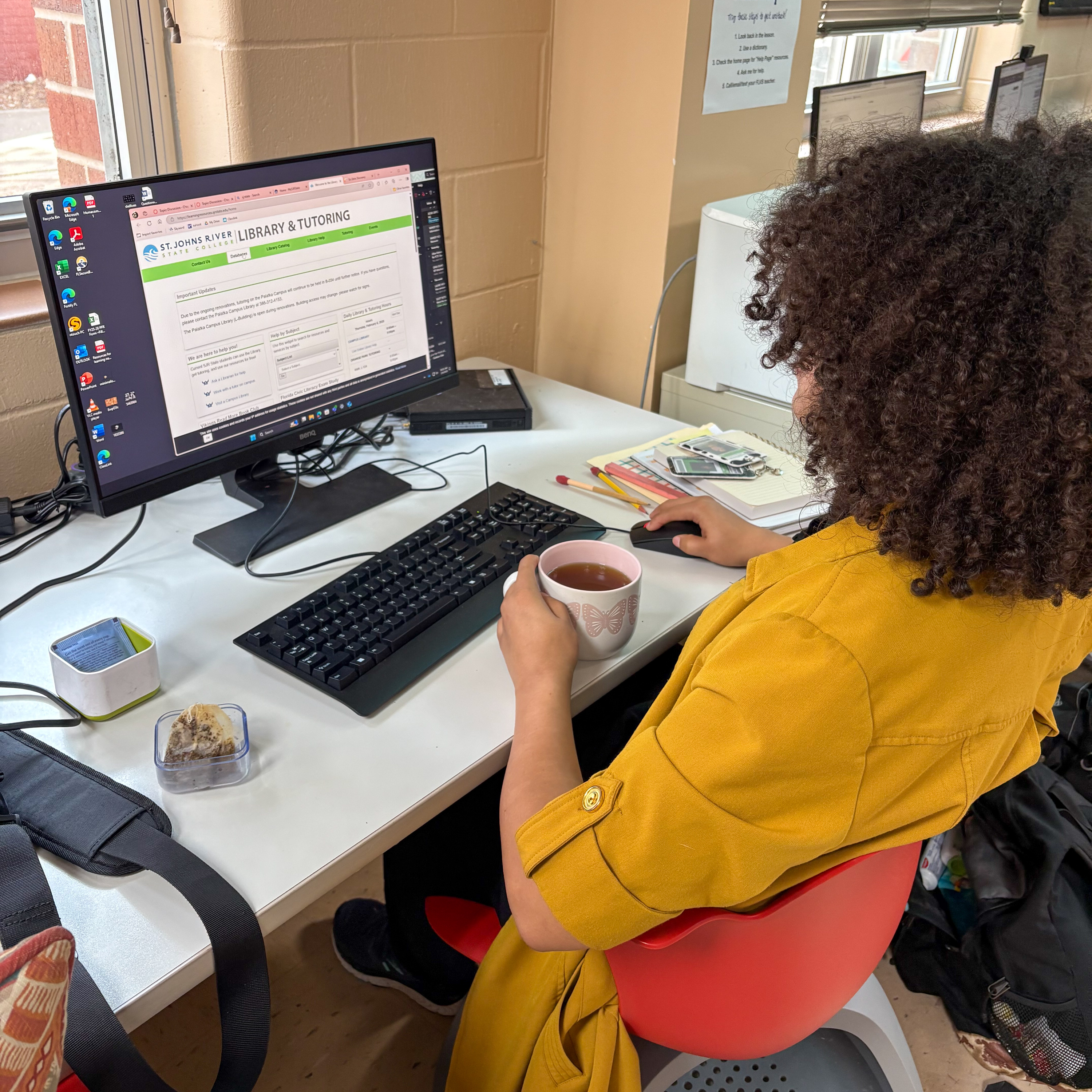 A students sitting at a computer doing an online assignment.