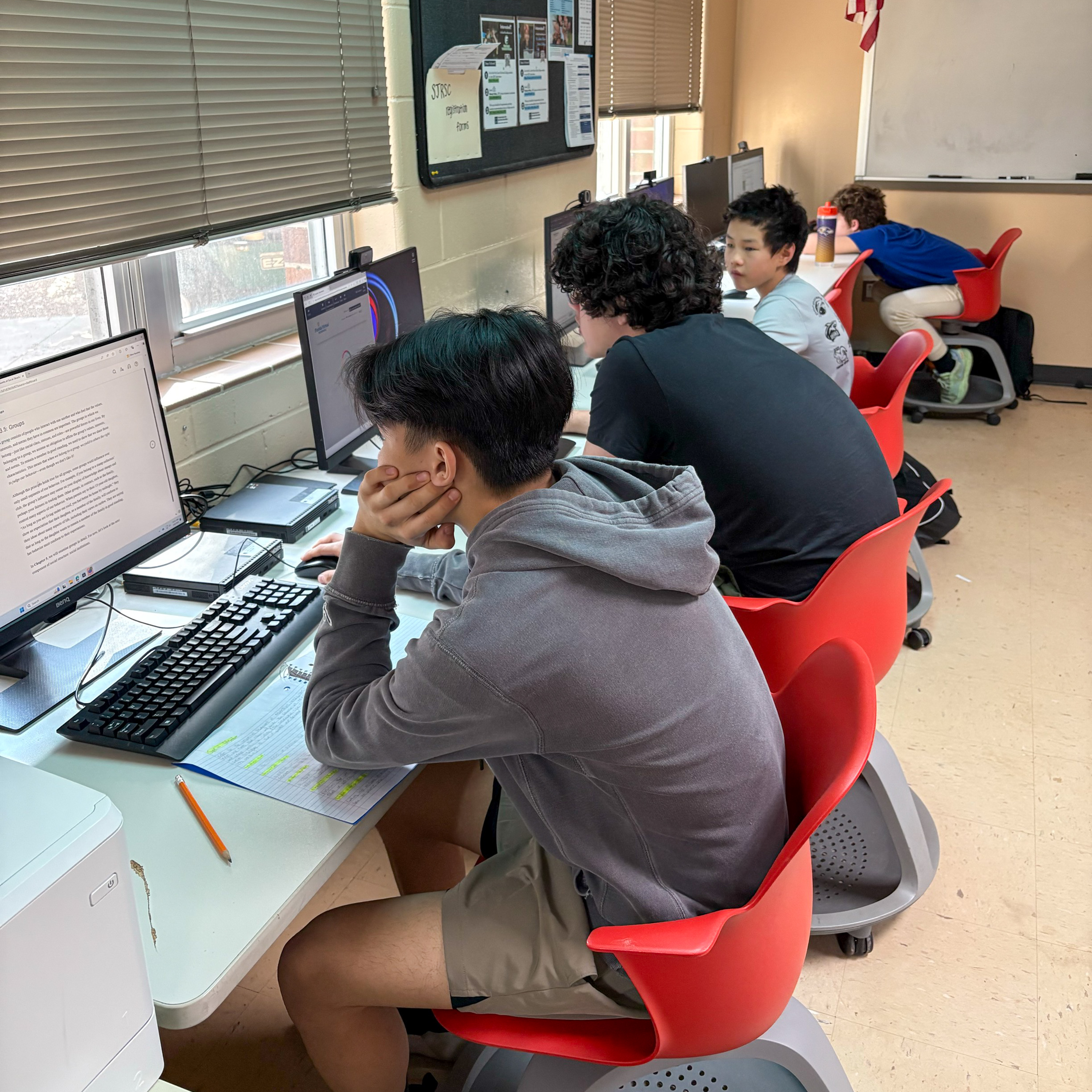 Four deaf boys doing classwork on computers.