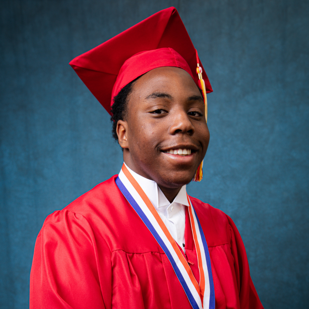 Tyler Bosket wearing a red cap and gown.