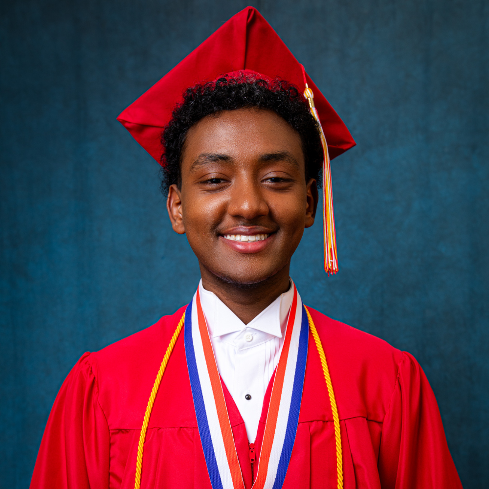 Senai Medhane wearing a red cap and gown.
