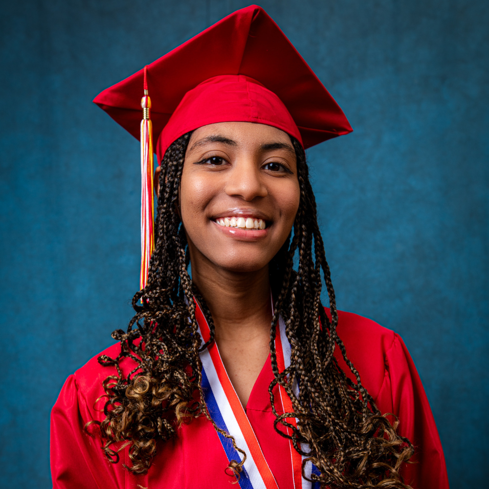 Myianeii Murray wearing a red cap and gown.