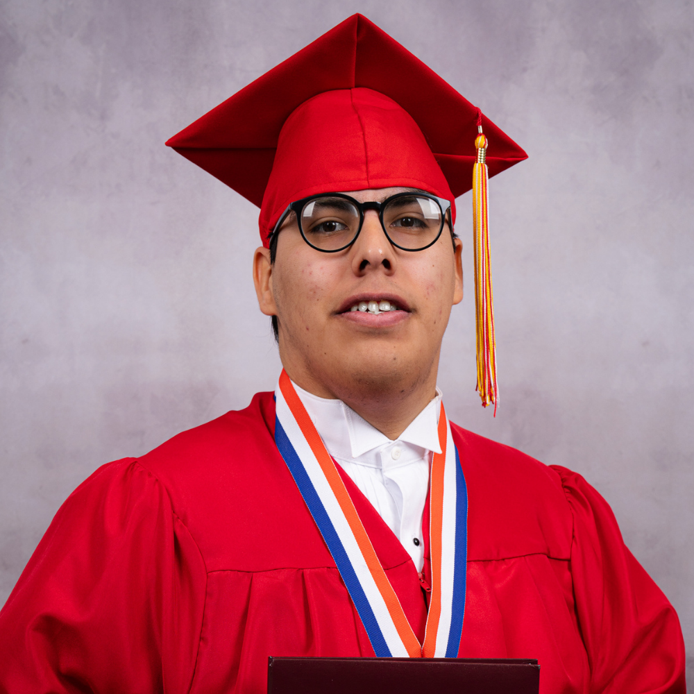 Juan Barrios wearing a red cap and gown.
