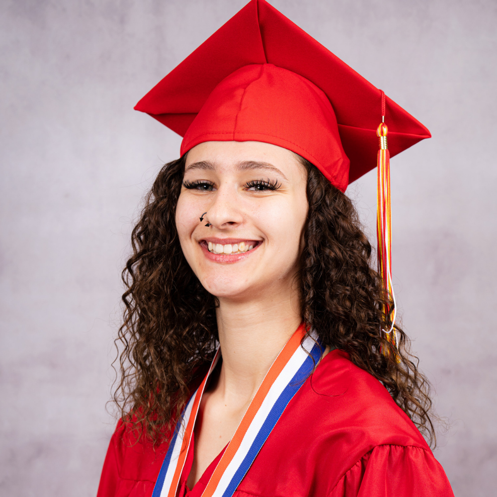 Skylar Bergman wearing a red cap and gown.