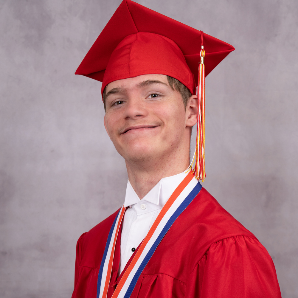 Alexzander Bishop wearing a red cap and gown.