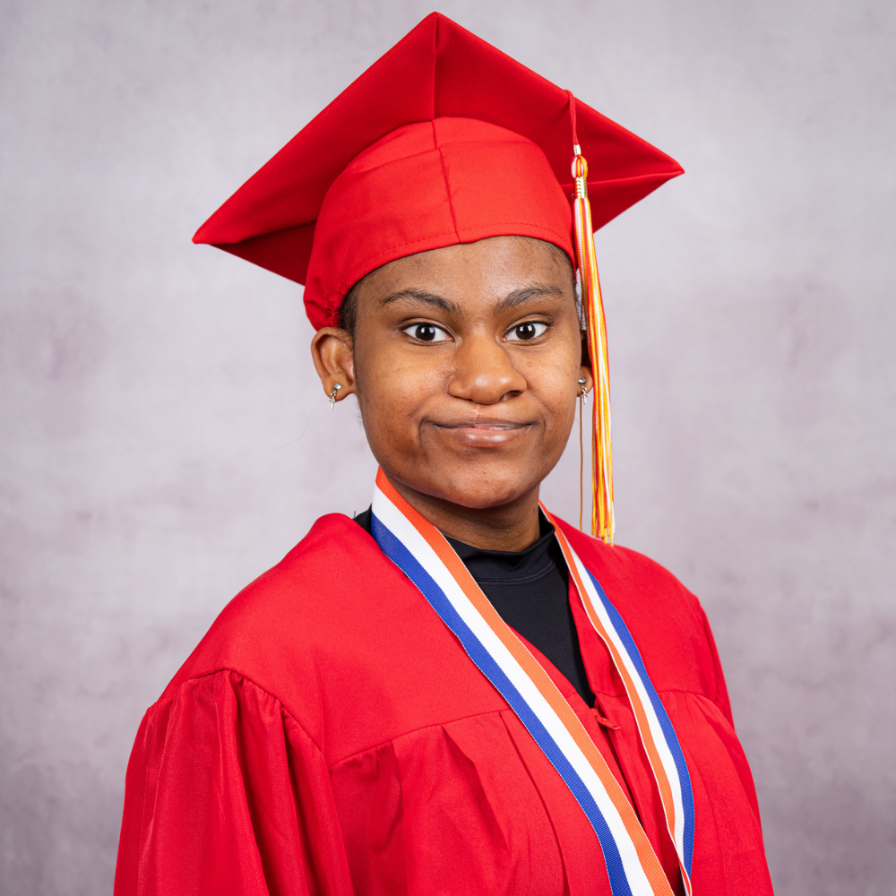 Jahnea Hankinson wearing a red cap and gown.