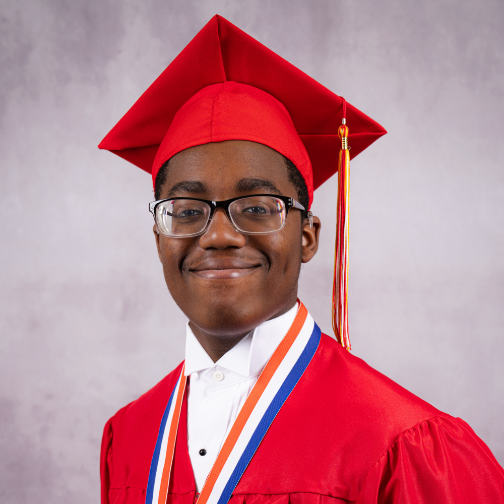 Joshulah Ishman Jr.  wearing a red cap and gown.