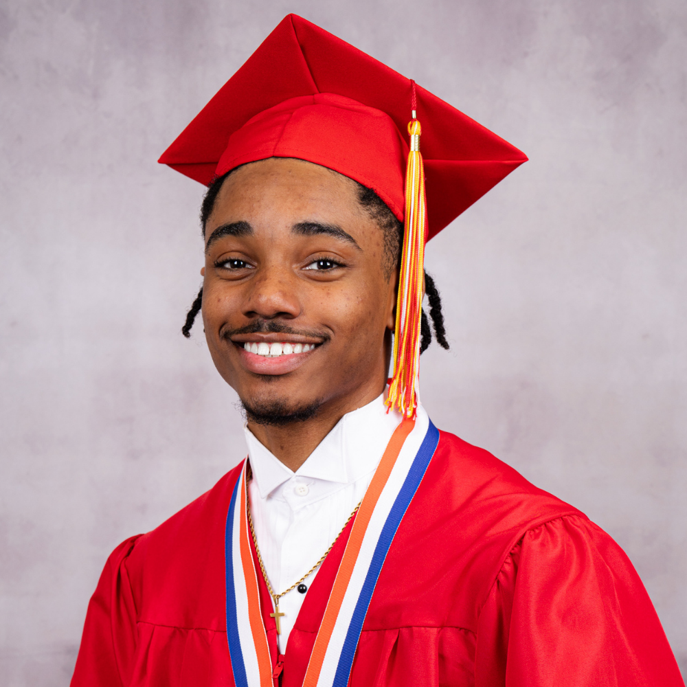 Xaviar Jones wearing a red cap and gown.