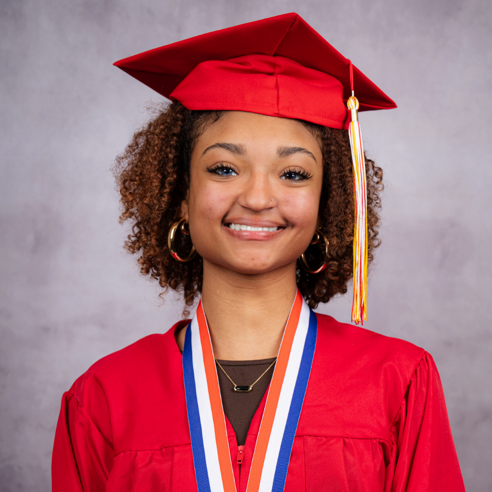 Giovanna Merchant wearing a red cap and gown.