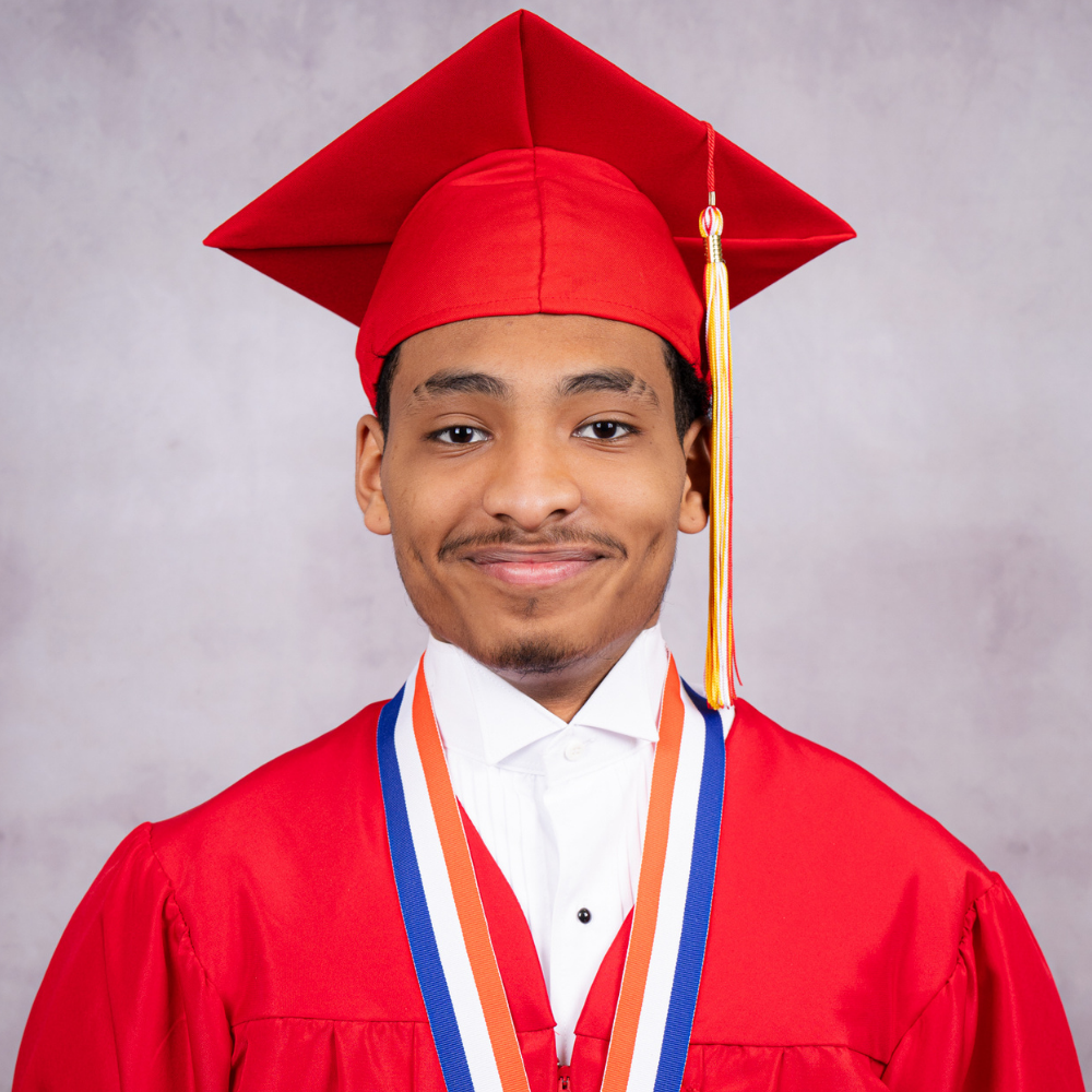 Antonio Riggins wearing a red cap and gown.