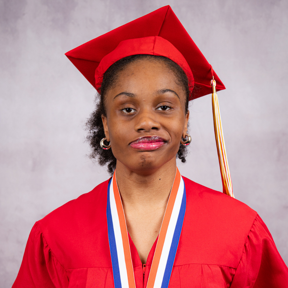 Chelcie Vilsaint wearing a red cap and gown.