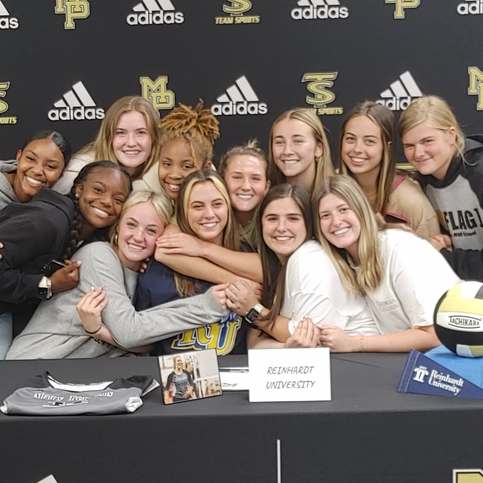 volleyball players hug a senior during her college signing day