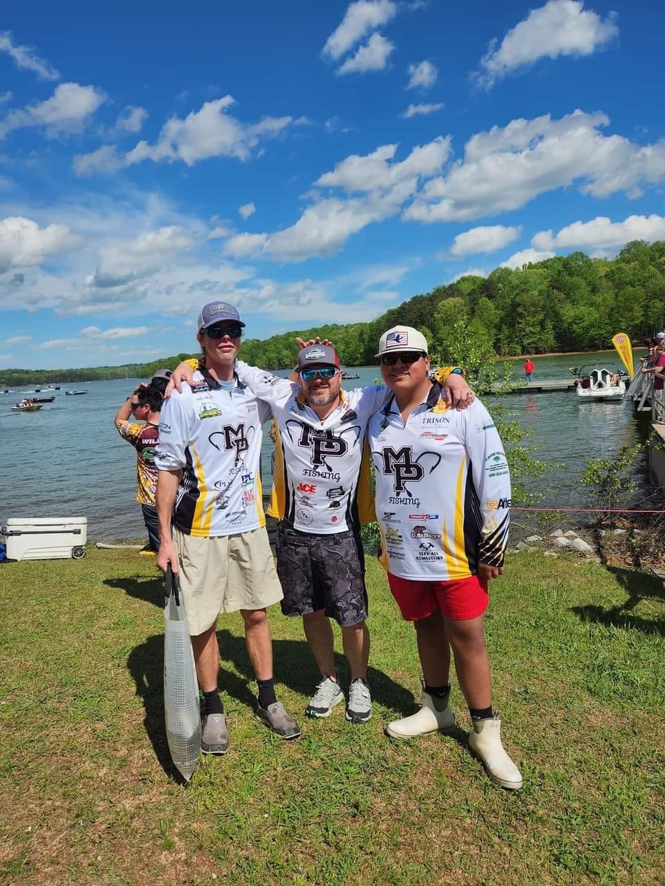 Three people posing with fish