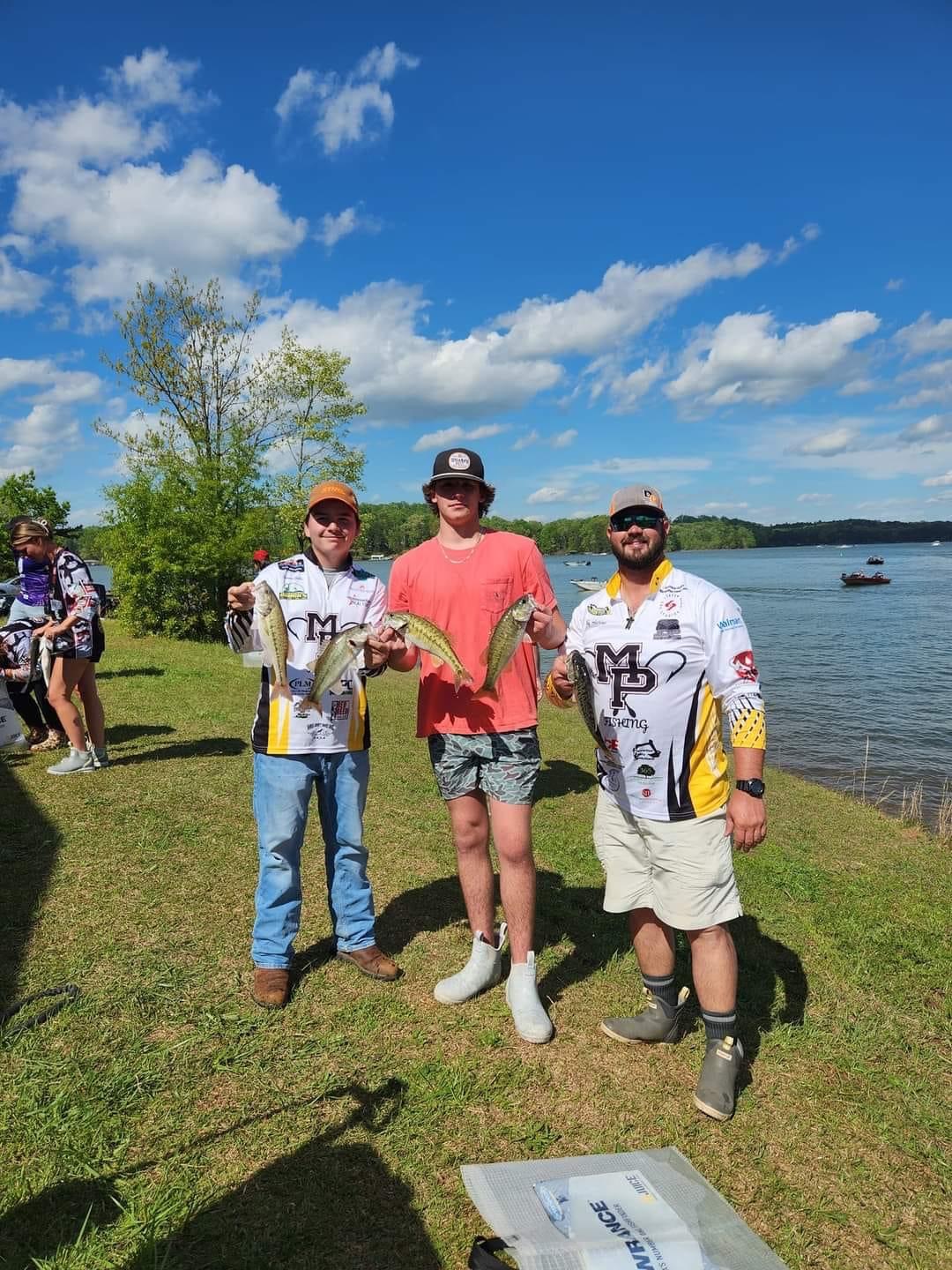 Three people posing with fish
