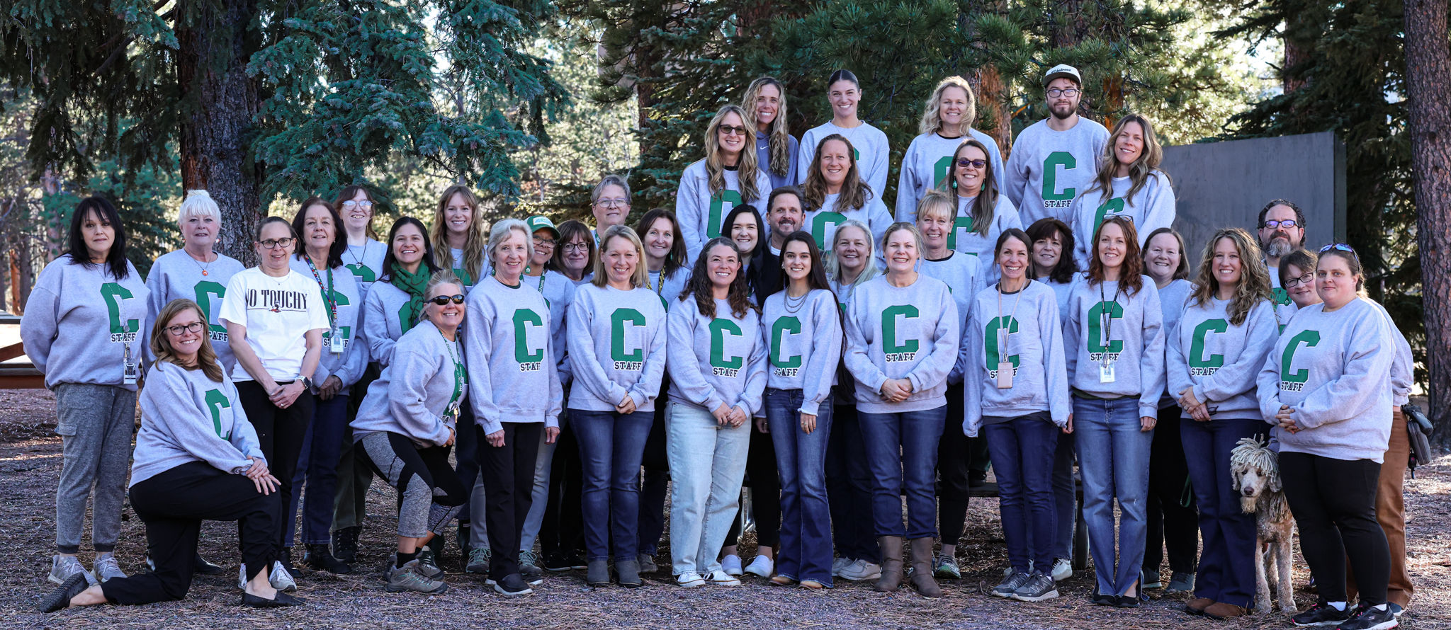 Columbine Staff group picture outside in front of evergreen trees