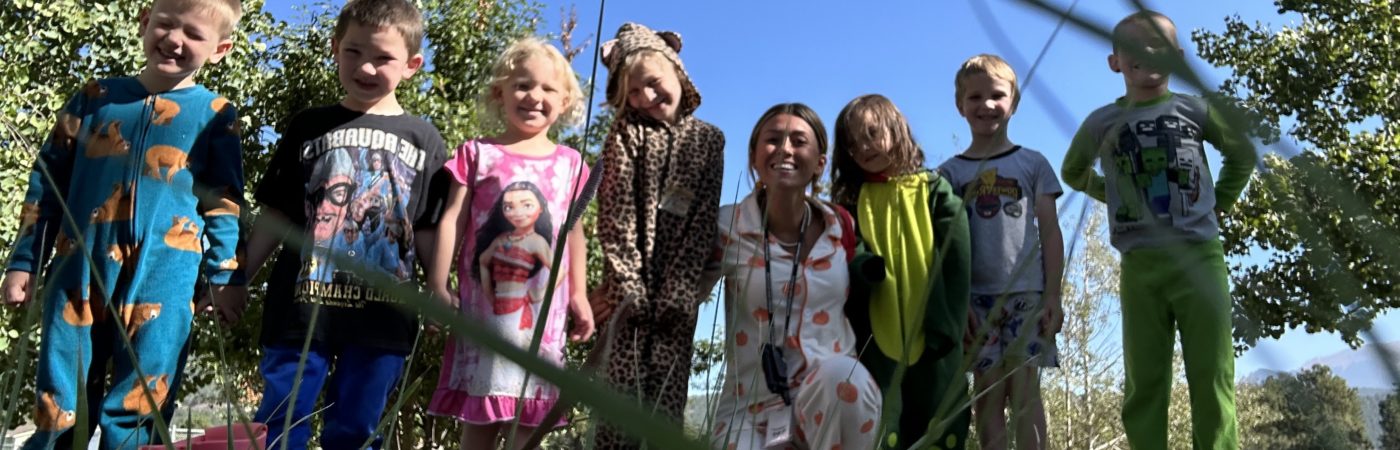 kids and teacher on the yard smiling to the camera 