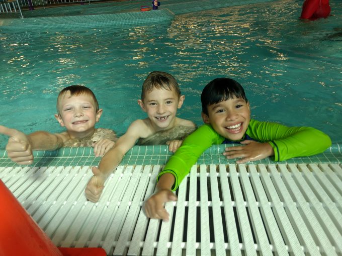 3 kids swimming on the pool 