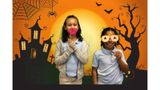 children posing in front of a Halloween-themed backdrop