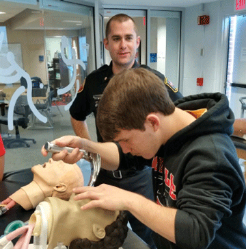 student in a simulator checking the throat.