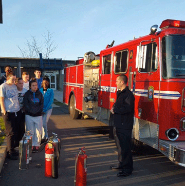 students posing for a picture with a fire truck