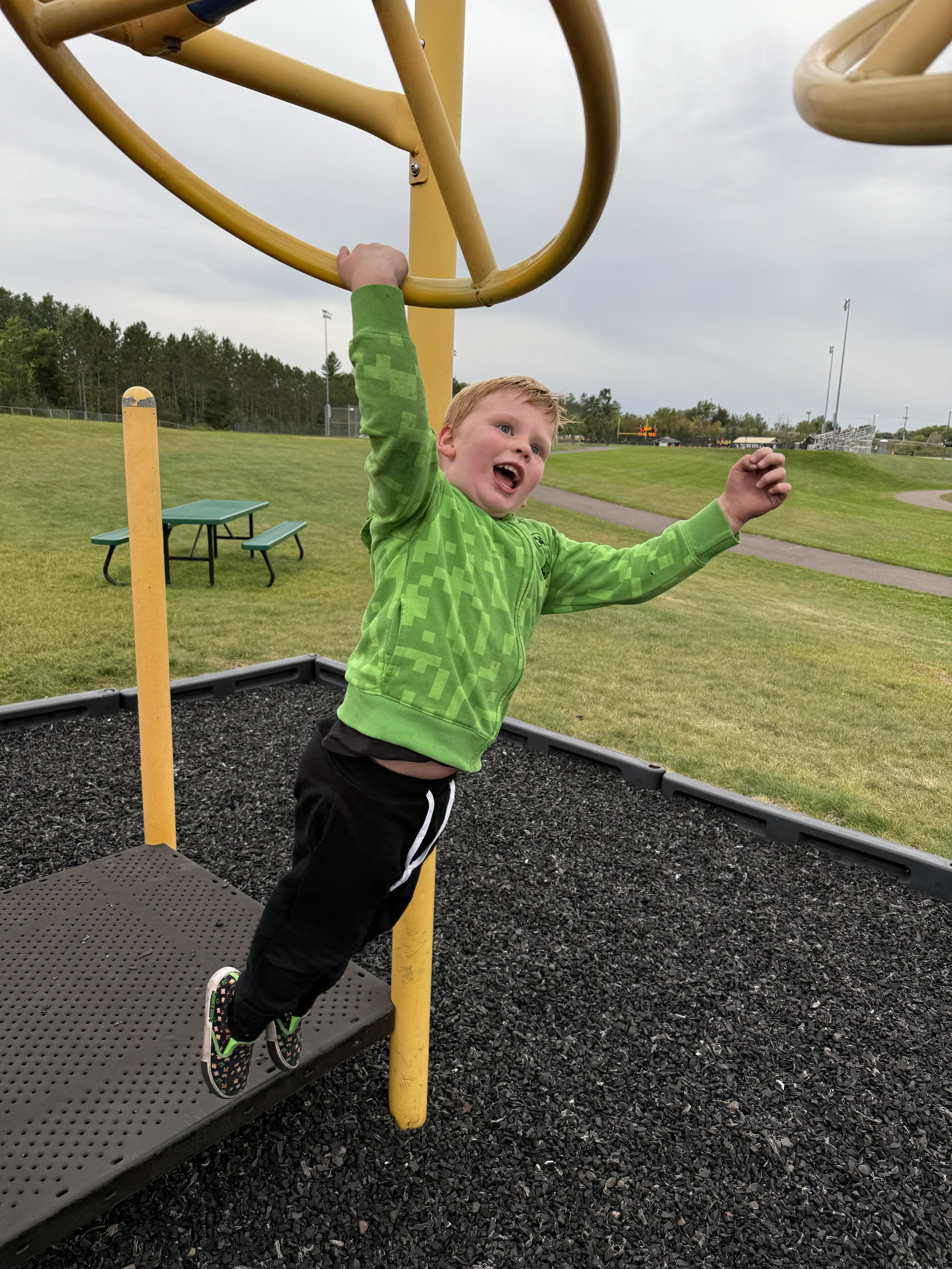 A Hornet Care student playing on playground equipment.