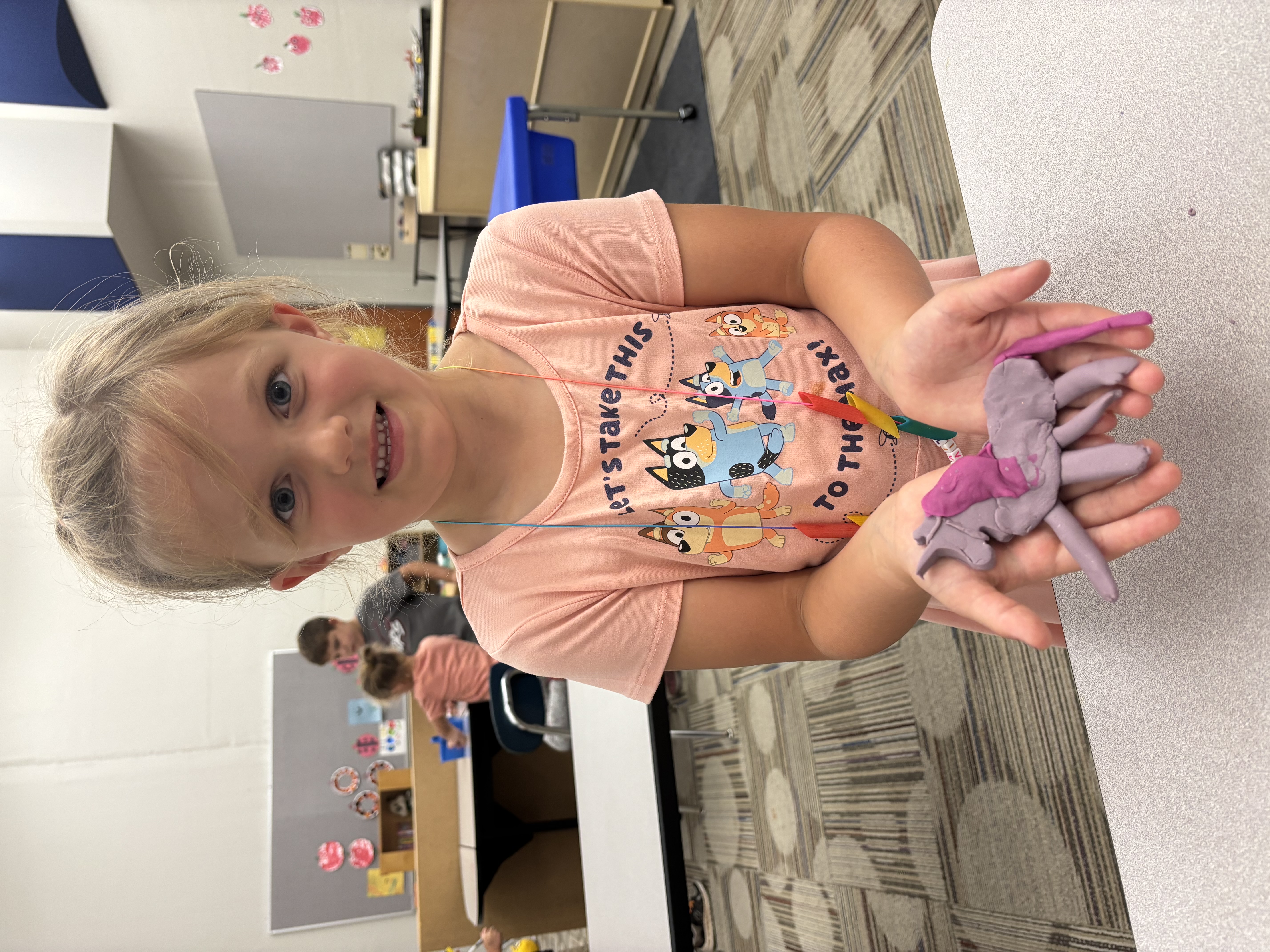 Hornet Care student holding out a unicorn made from Play-Dough.