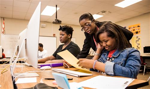 Teacher helping out students